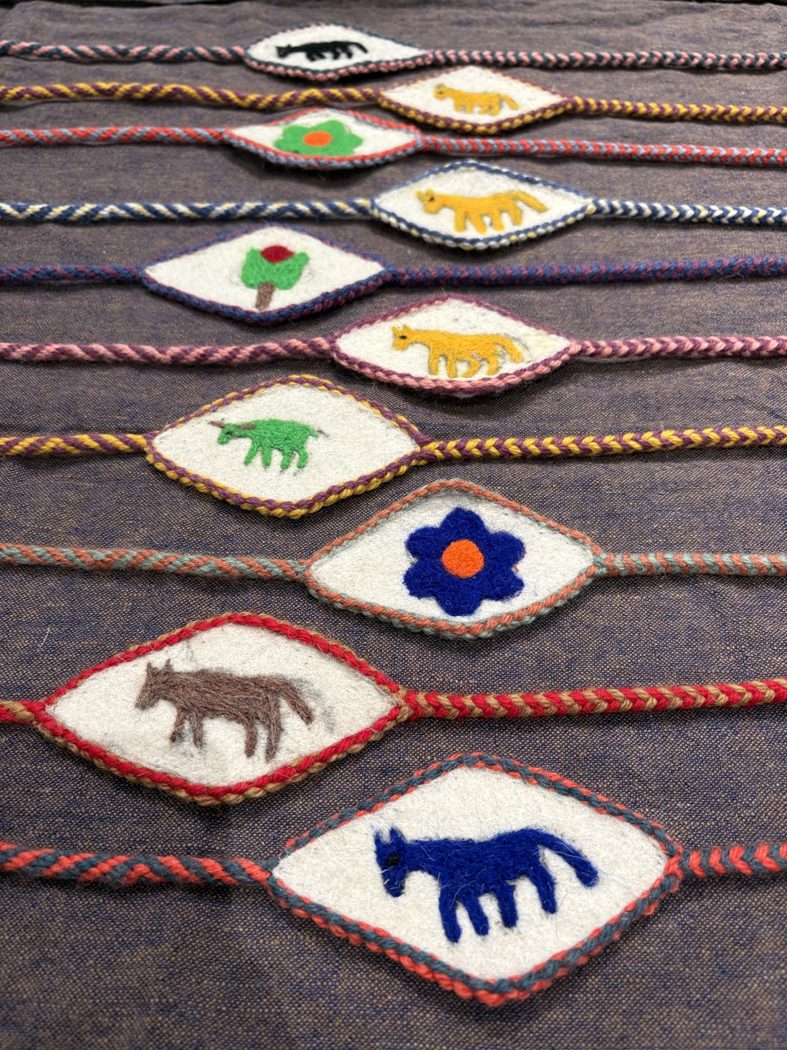 Multiple handwoven Wurdoo pieces with animal and flower motifs