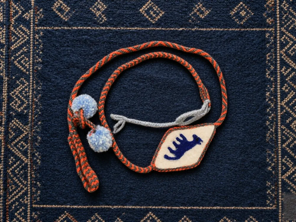 Animal A03 — Red-brown cord · Blue-hand panel · Blue-white poms