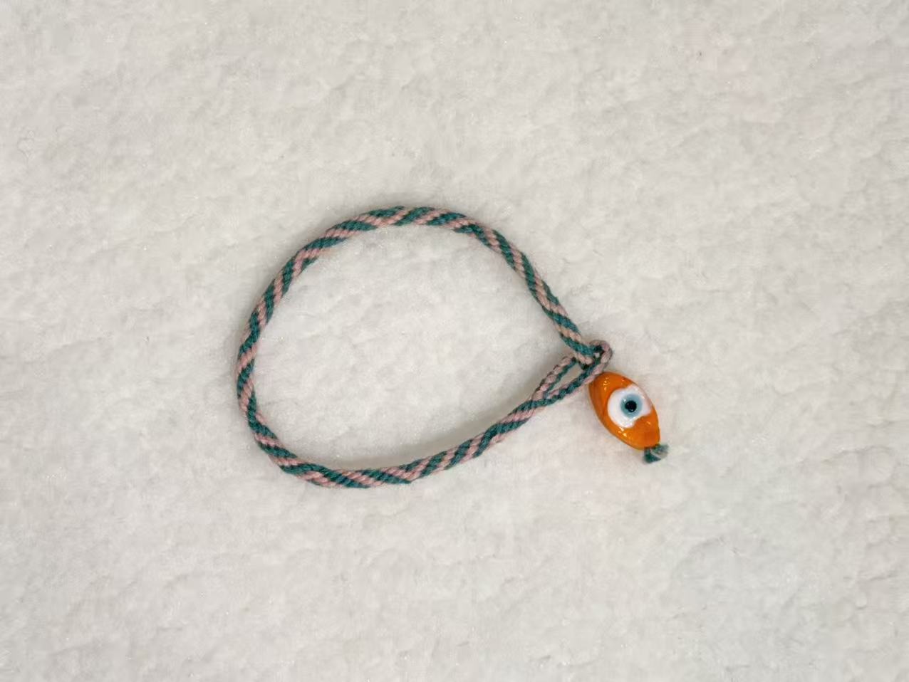 Evil Eye E05 — Teal & cream · Orange charm