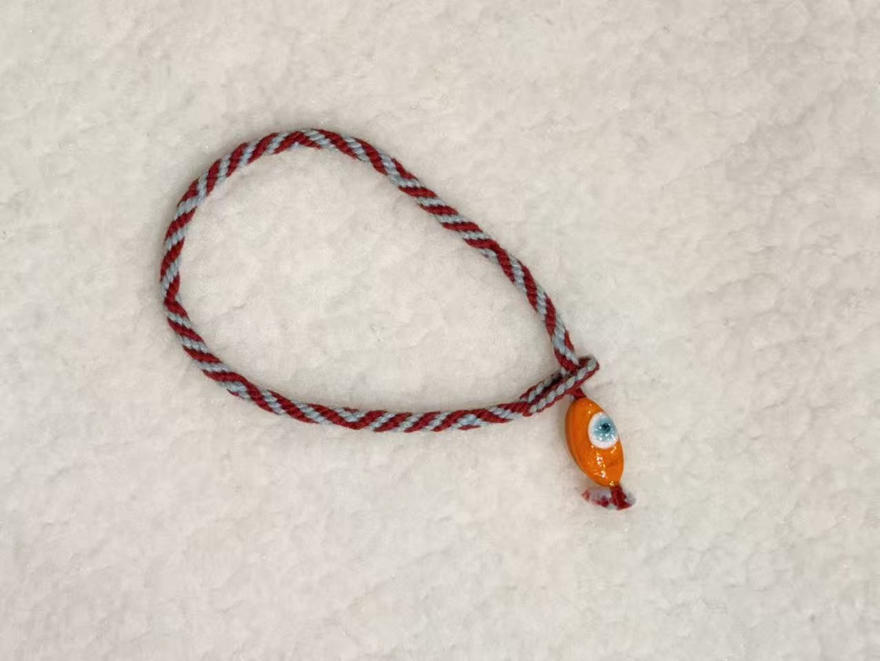 Evil Eye E09 — Burgundy & cream · Orange charm