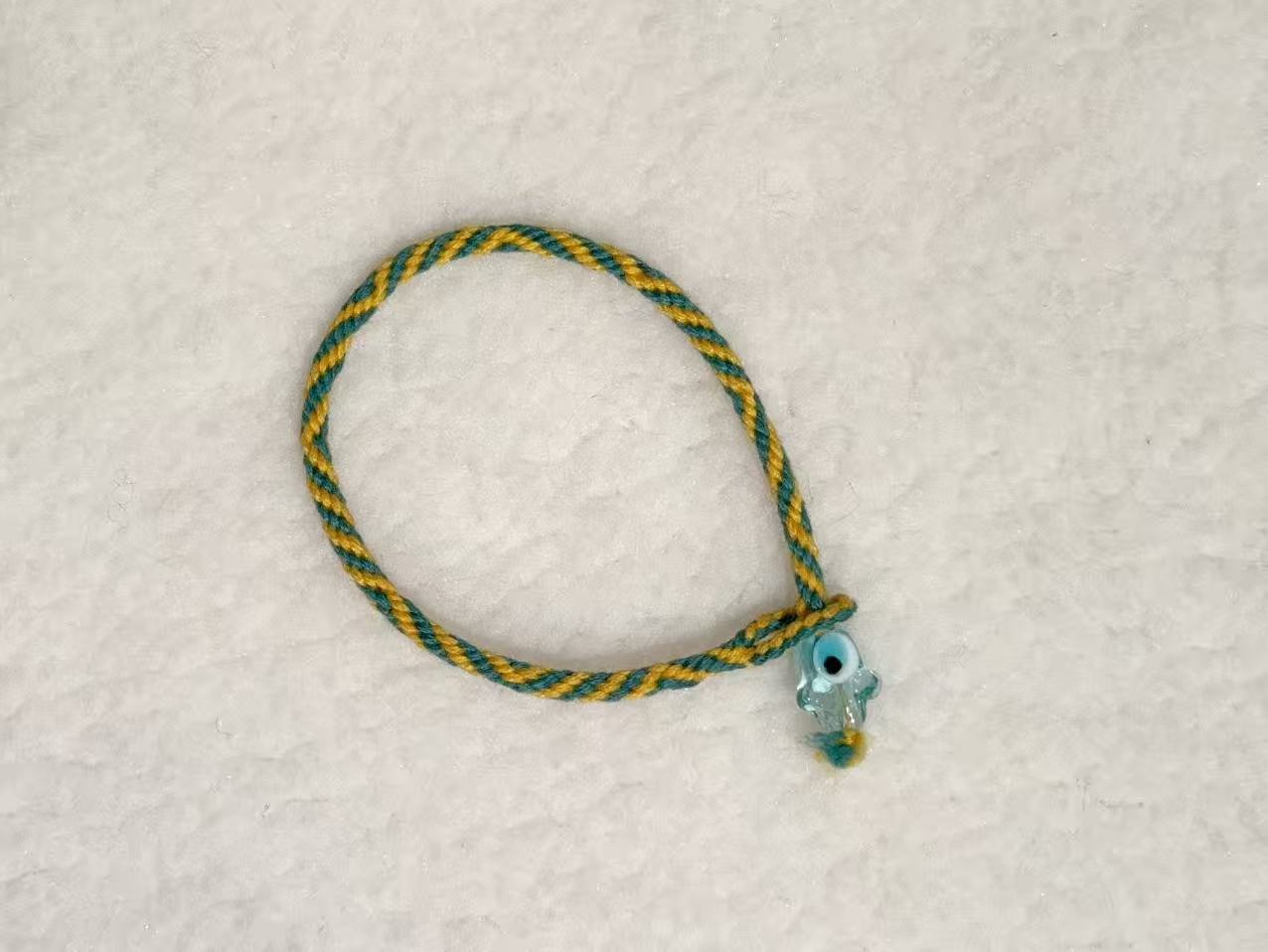 Evil Eye E13 — Green & gold · Pale charm