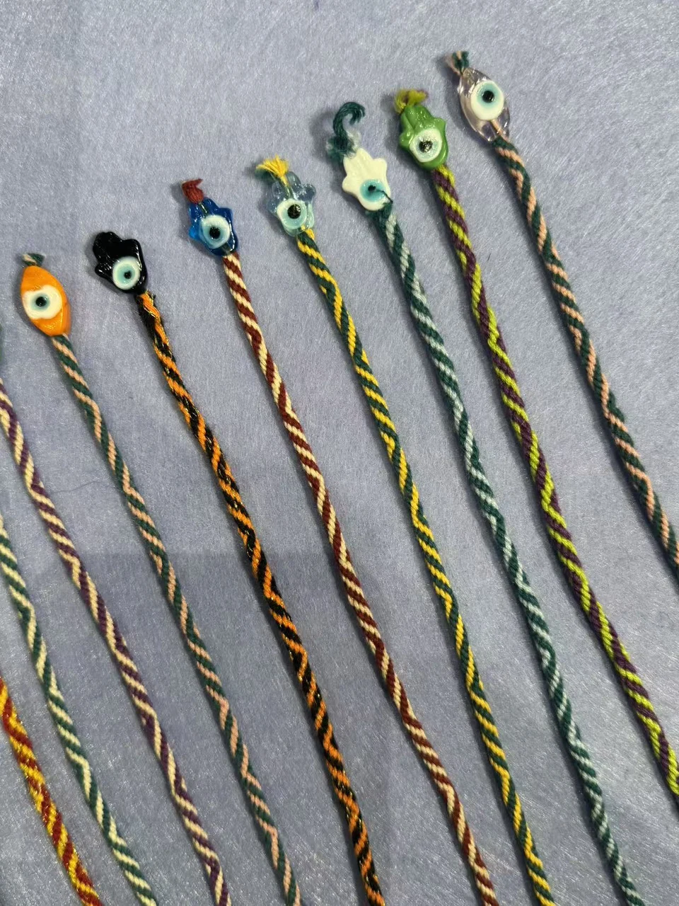 Row of nine-eye bracelets with colourful nazar beads on handwoven cords